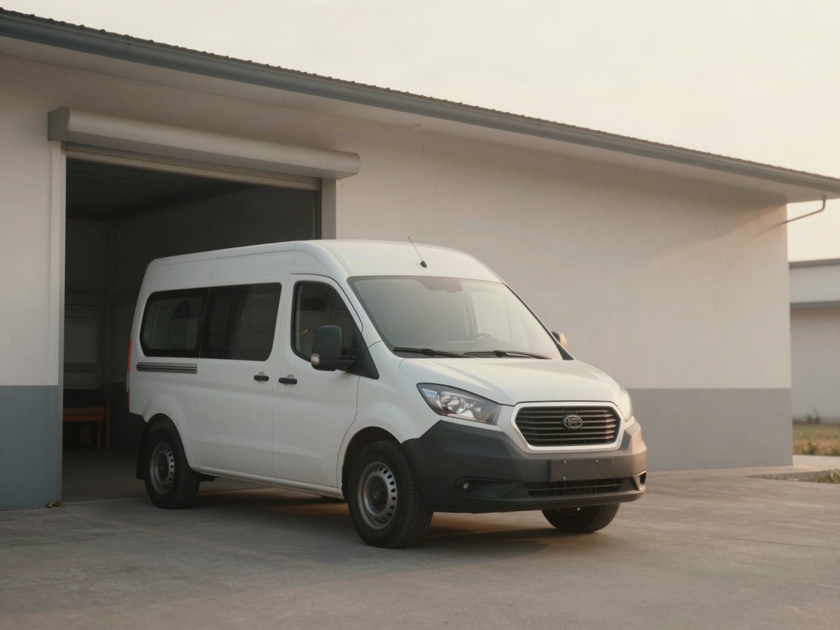A single white delivery van parked outside a small warehouse loading bay in early morning light.